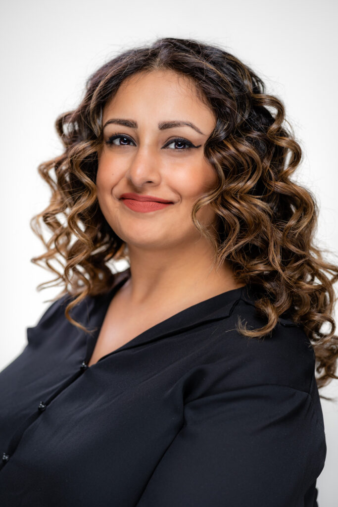 Professional studio headshot with a white backdrop.