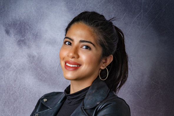 Kristina headshot against a gray painted studio background.